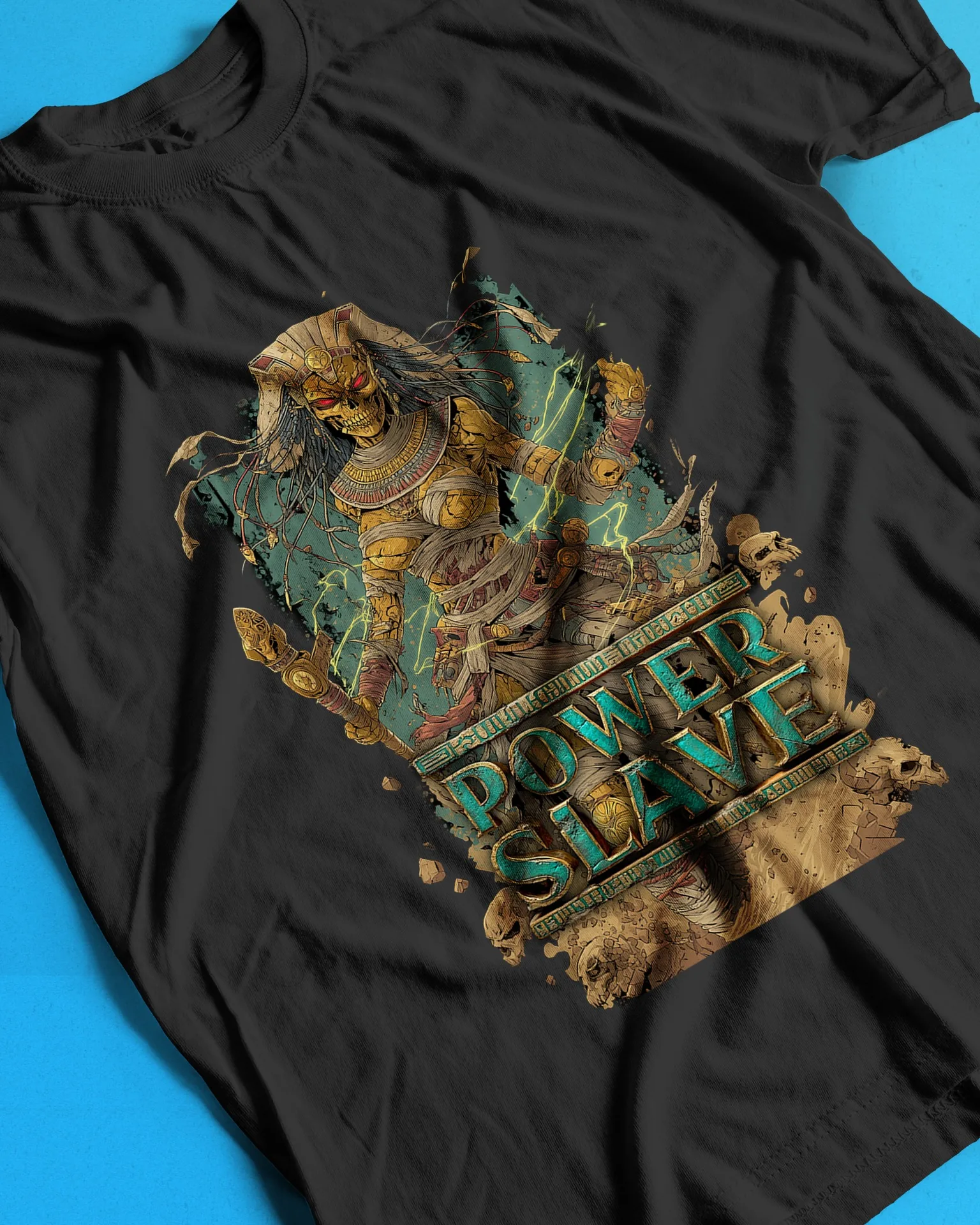Mummified pharaoh with glowing red eyes and a golden staff, with carved turquoise Powerslave lettering, printed on a black shirt
